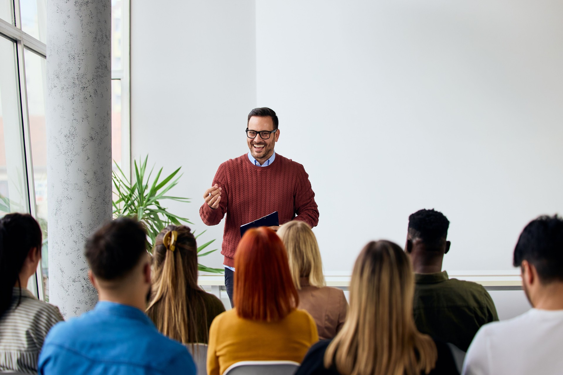 Trener A-KWADRAT Klaudia Kaczmarek prowadzi szkolenie metodami aktywnymi. Grupa uczestników słucha prelegenta podczas warsztatów.