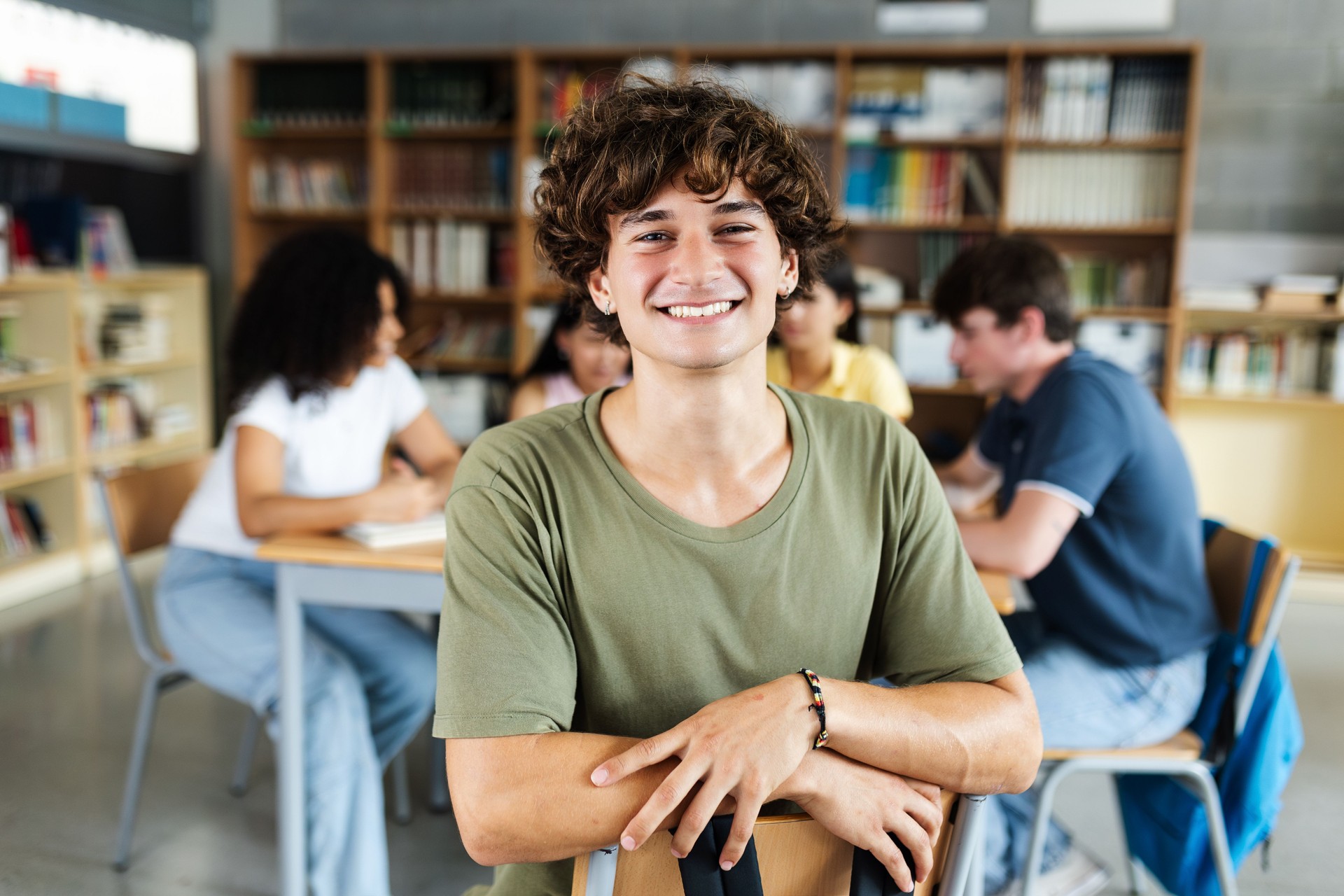 Uśmiechnięty uczeń siedzi w klasie podczas programu edukacyjnego Fundacji Healio Studio wspierającego uważność i współpracę rówieśniczą.